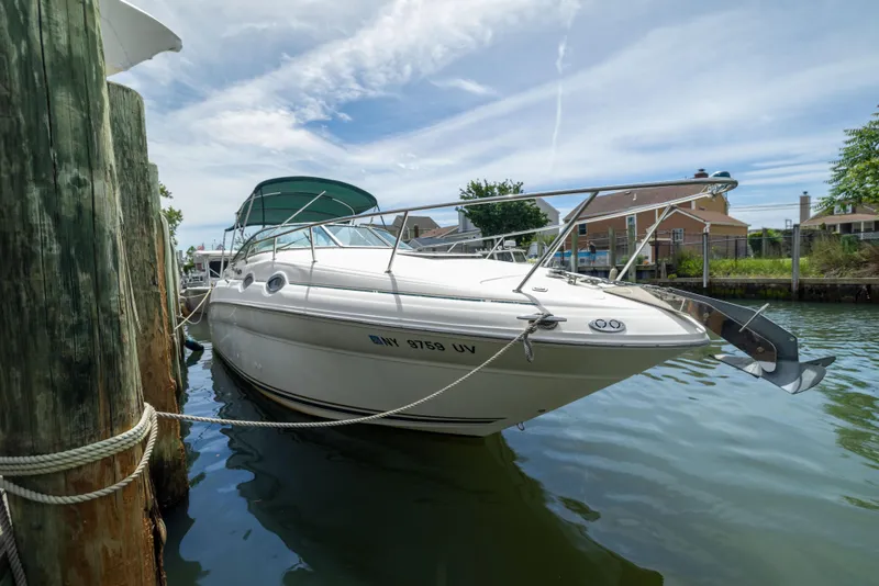 The Image of 2002 Searay 260 Sundancer boat docked in a marina under a clear sky. - 1