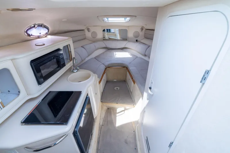 Slide: The Image of Interior of 2002 Searay 260 Sundancer boat with kitchenette and seating area. - 11