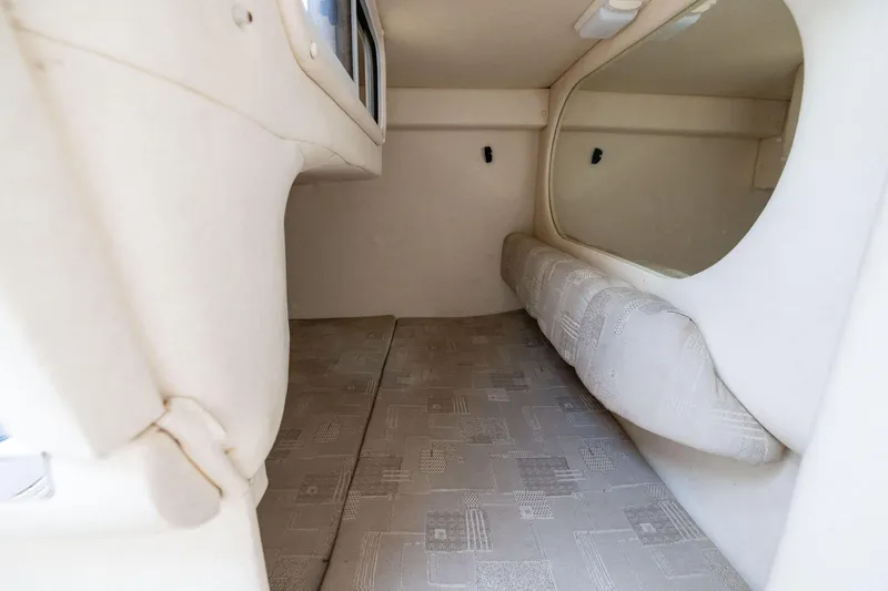 Slide: The Image of Interior cabin of 2002 Searay 260 Sundancer, featuring cozy sleeping area and soft furnishings. - 12