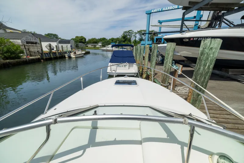 Slide: The Image of 2002 Searay 260 Sundancer docked at Amity Harbor marina, surrounded by calm water. - 14