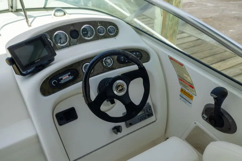Slide: The Image of 2002 Searay 260 Sundancer helm with steering wheel, gauges, and navigation system. - 15