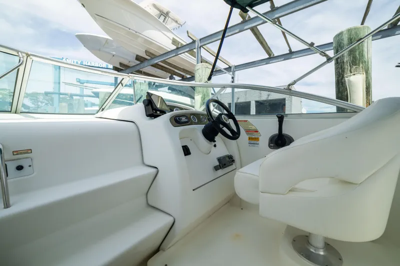 Slide: The Image of 2002 Searay 260 Sundancer boat interior with steering wheel and seating. - 16