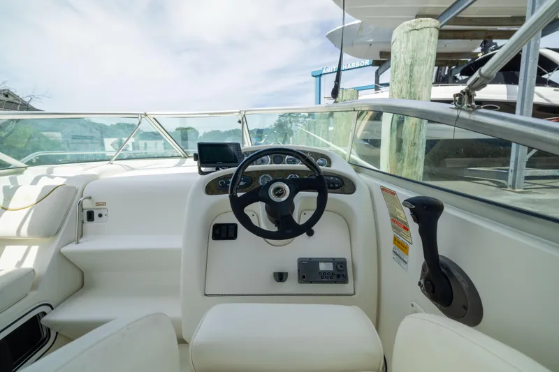 Slide: The Image of 2002 Searay 260 Sundancer boat cockpit with steering wheel and control panel. - 18