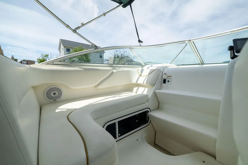 Slide: The Image of Interior view of 2002 Searay 260 Sundancer boat, featuring white seating and clear canopy. - 19