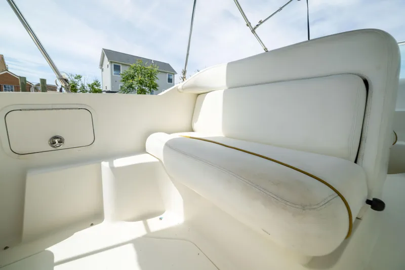 Slide: The Image of Interior seating of 2002 Searay 260 Sundancer boat, featuring white upholstery. - 24
