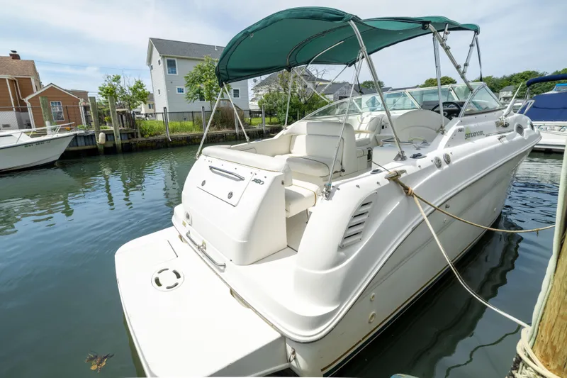 Slide: The Image of 2002 Searay 260 Sundancer boat docked in a serene marina setting. - 3