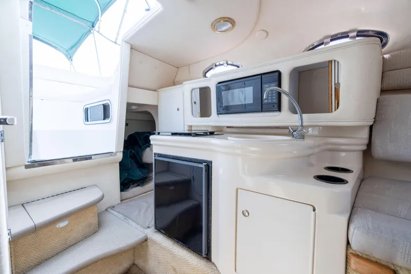 Slide: The Image of Interior of 2002 Searay 260 Sundancer boat with kitchenette and seating area. - 7