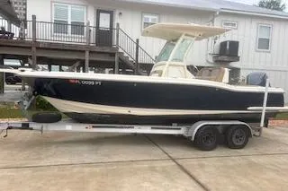The Image of 2014 Scout 240 Bay Scout boat on trailer, parked in front of a house. - 1