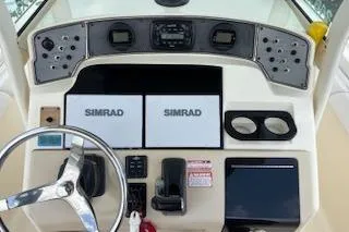 Slide: The Image of 2014 Scout 240 Bay Scout boat dashboard with Simrad navigation displays. - 12