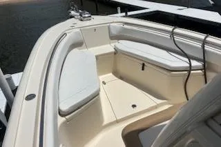 Slide: The Image of 2014 Scout 240 Bay Scout boat interior with cushioned seating and storage compartments. - 5