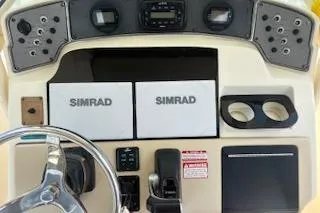 Slide: The Image of 2014 Scout 240 Bay Scout boat dashboard with Simrad navigation system and steering wheel. - 6