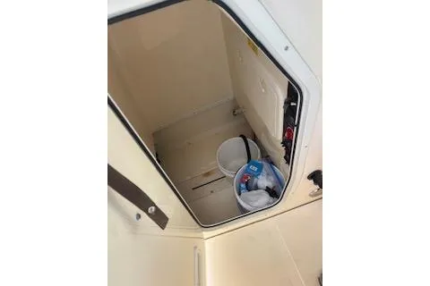 Slide: The Image of 2014 Scout 240 Bay Scout storage compartment with buckets and supplies. - 8