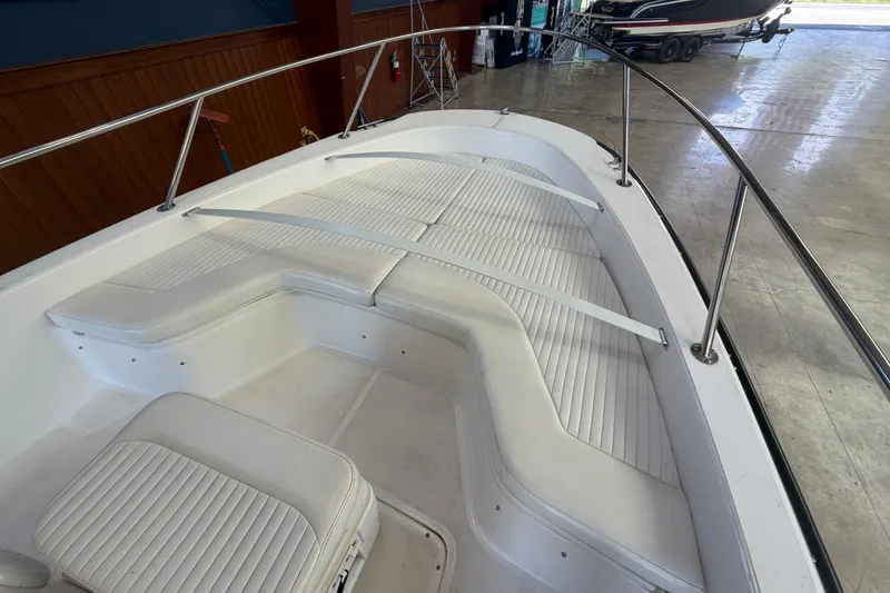 Slide: The Image of 2004 Boston Whaler 220 Dauntless boat interior with white cushioned seating and railings. - 10