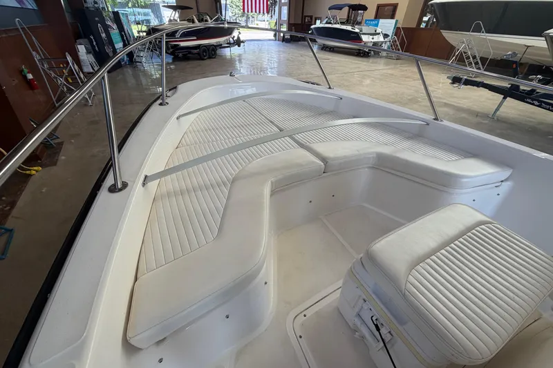 Slide: The Image of 2004 Boston Whaler 220 Dauntless boat interior with white cushioned seating. - 12