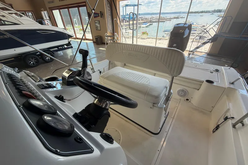 Slide: The Image of Interior view of a 2004 Boston Whaler 220 Dauntless boat, showcasing the helm and seating. - 13