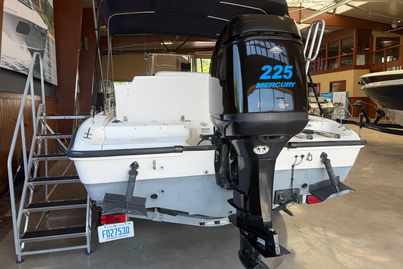 Slide: The Image of 2004 Boston Whaler 220 Dauntless with Mercury 225 engine displayed indoors. - 3