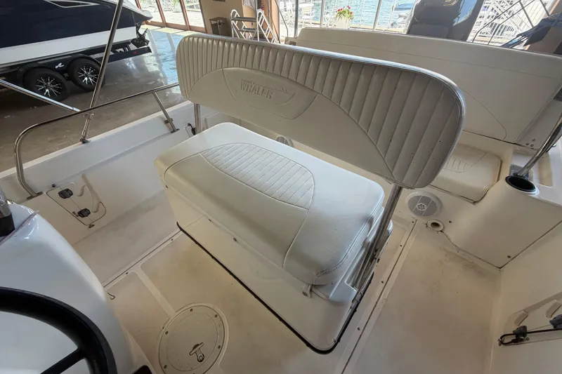 Slide: The Image of 2004 Boston Whaler 220 Dauntless boat interior with cushioned seating and storage. - 6