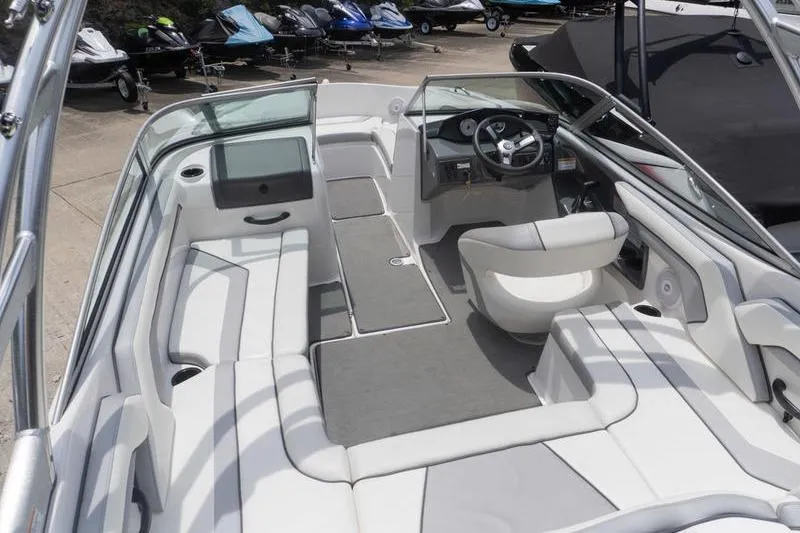 Slide: The Image of 2017 Yamaha Boats AR190 interior with seating and steering wheel, parked near other watercraft. - 25