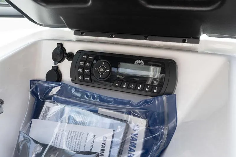 Slide: The Image of 2017 Yamaha Boats AR190 dashboard with stereo system and manuals in storage compartment. - 35