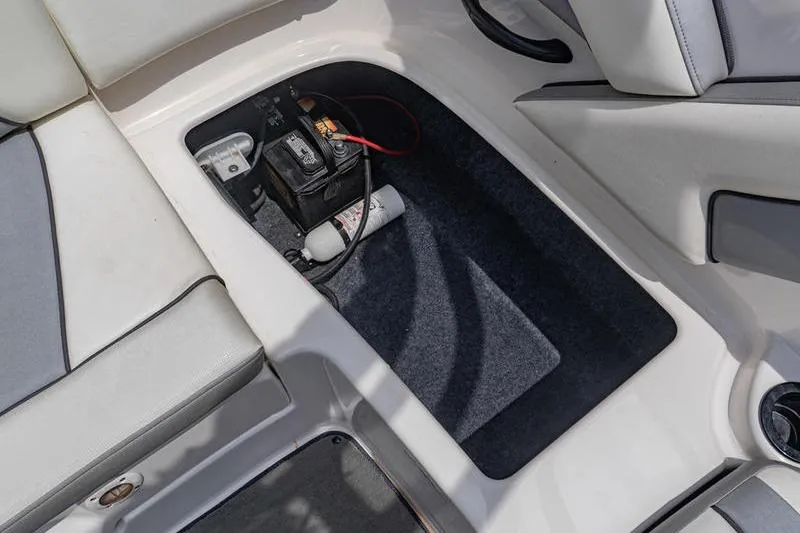 Slide: The Image of 2017 Yamaha Boats AR190 storage compartment with battery and fire extinguisher. - 43