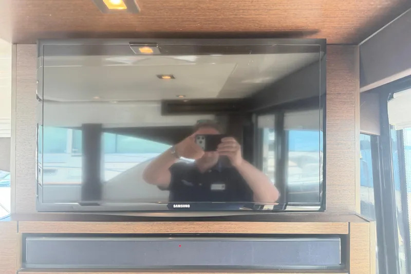 Slide: The Image of Samsung TV inside 2016 Tiara Yachts C39 Coupe, reflecting interior and person taking photo. - 13