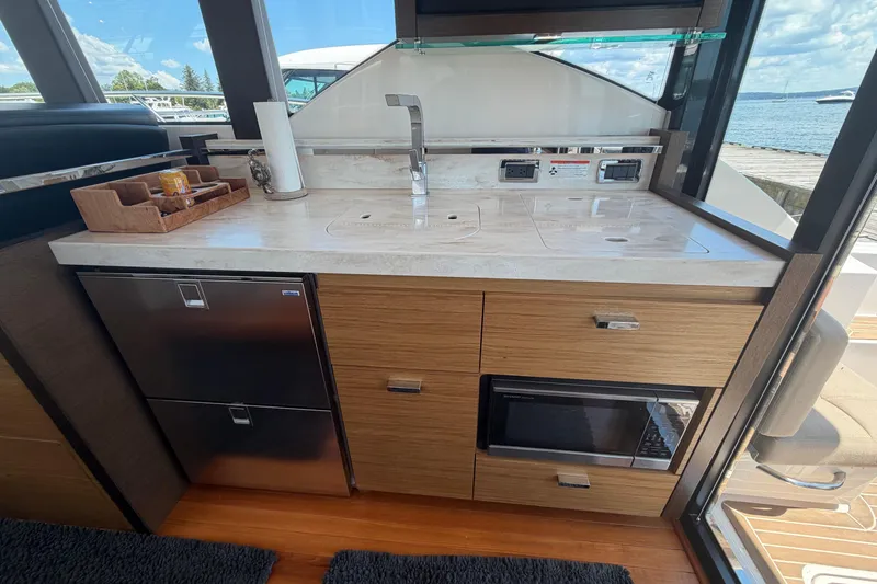 Slide: The Image of Modern kitchen area in a 2016 Tiara Yachts C39 Coupe, featuring sleek cabinetry and appliances. - 14