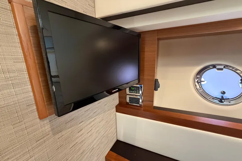 Slide: The Image of Flat-screen TV and porthole in 2016 Tiara Yachts C39 Coupe interior. - 24