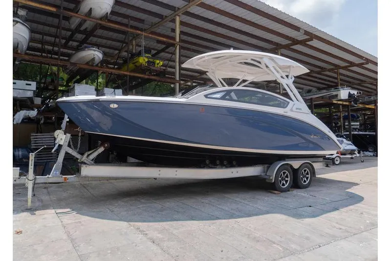 The Image of 2023 Yamaha Boats 275SDX on trailer in covered storage area. - 1