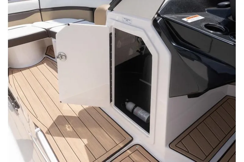 Slide: The Image of Open storage compartment on 2023 Yamaha Boats 275SDX with teak flooring and seating. - 11