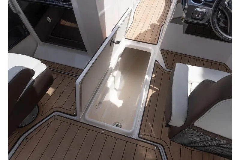 Slide: The Image of 2023 Yamaha Boats 275SDX interior with open storage compartment and seating. - 12