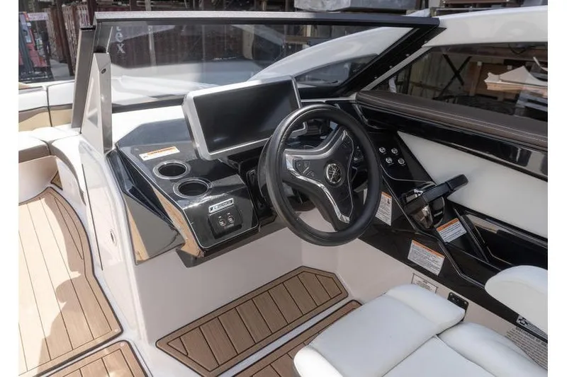Slide: The Image of 2023 Yamaha Boats 275SDX helm with modern steering wheel and digital display. - 13