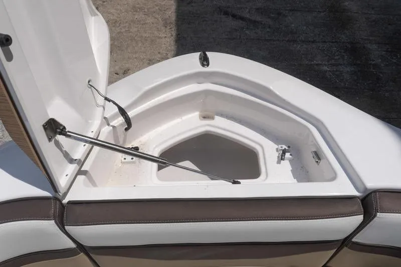 Slide: The Image of Open storage compartment on 2023 Yamaha Boats 275SDX, featuring cushioned seating and hydraulic support. - 21