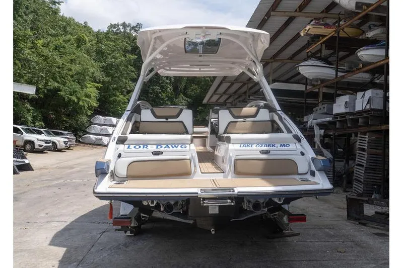 Slide: The Image of 2023 Yamaha Boats 275SDX in storage, rear view with seating and canopy. - 3