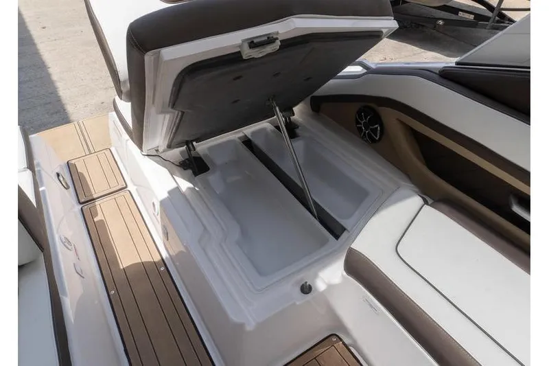 Slide: The Image of 2023 Yamaha Boats 275SDX storage compartment with open seat, showcasing interior features. - 32