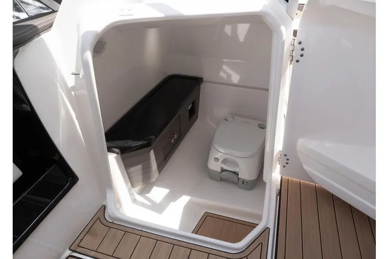 Slide: The Image of 2023 Yamaha Boats 275SDX interior cabin with compact toilet and storage. - 9