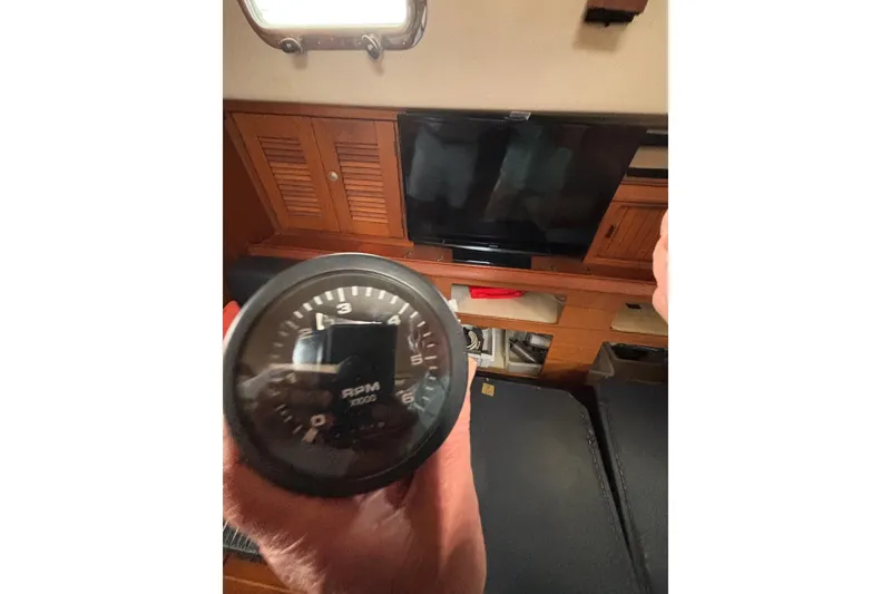Slide: The Image of RPM gauge inside 1999 Island Packet 45 yacht cabin with wooden cabinetry. - 16