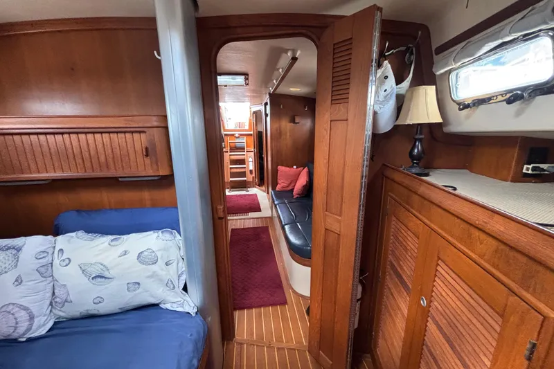 Slide: The Image of Interior of 1999 Island Packet 45 sailboat with cozy wooden furnishings and nautical decor. - 19