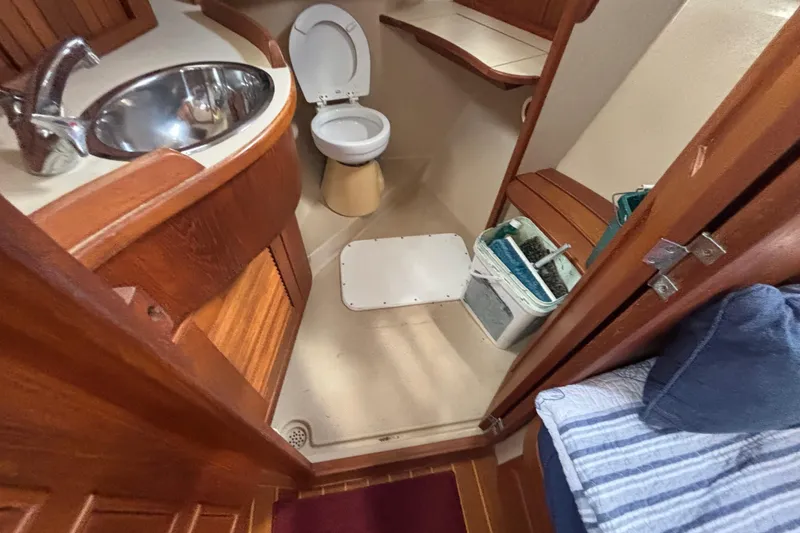 Slide: The Image of Bathroom interior of a 1999 Island Packet 45 sailboat, featuring a sink and toilet. - 21