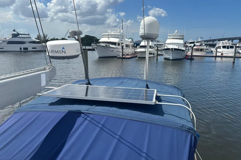 Slide: The Image of Sailboat Island Packet 45 (1999) with solar panel docked at marina under blue sky. - 27