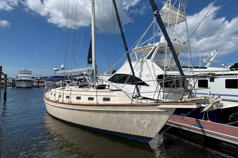 Slide: The Image of 1999 Island Packet 45 sailboat docked at marina under blue sky. - 32
