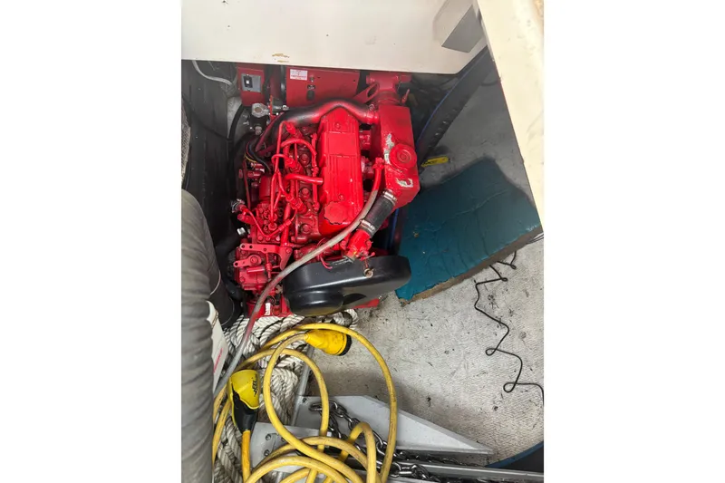 Slide: The Image of Engine compartment of a 1999 Island Packet 45 sailboat with red engine and cables. - 35