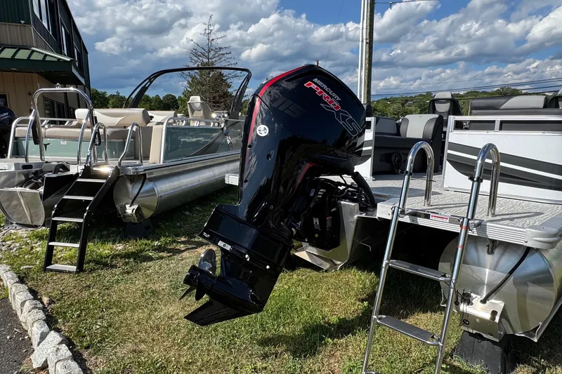 Slide: The Image of 2026 Tahoe Pontoon Sport 85 Quad Lounger 23 with powerful outboard motor, docked outdoors. - 16