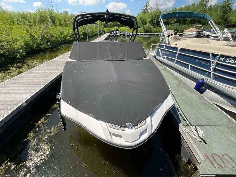 Slide: The Image of A 2025 Yamaha 222SD boat docked, featuring a black cover. - 24