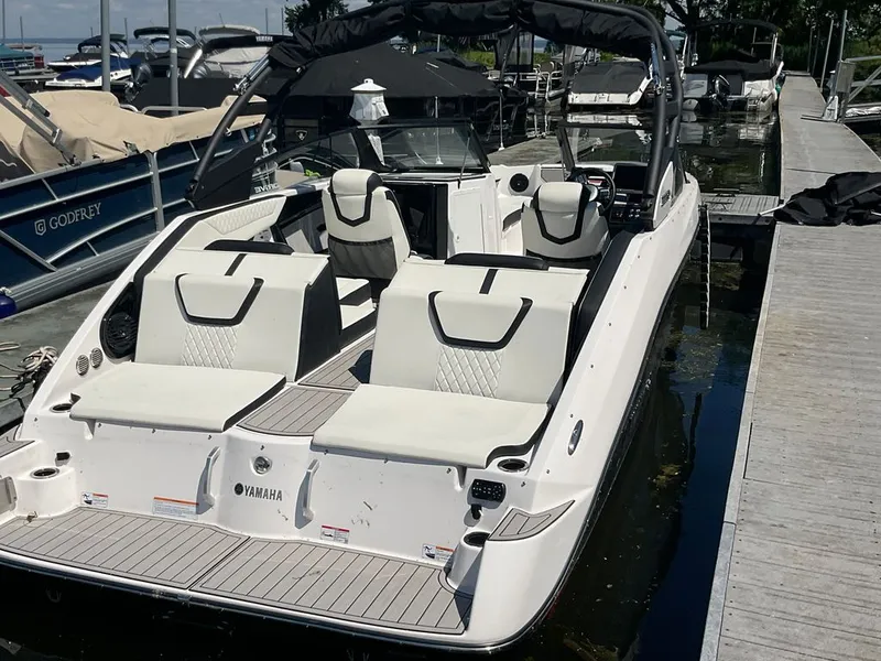Slide: The Image of A 2025 Yamaha 222SD boat docked. It features white seating and a black canopy. - 21