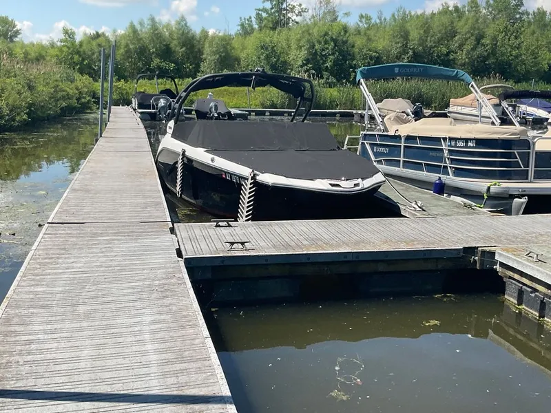 Slide: The Image of A 2025 Yamaha 222SD boat docked at a wooden pier in calm waters. - 26