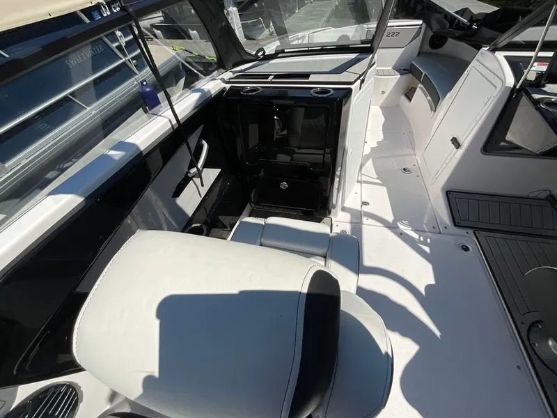 Slide: The Image of Interior of a modern boat with white seating and a black dashboard. - 11