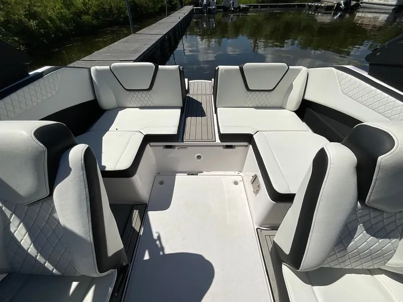 Slide: The Image of Interior view of a modern boat with white cushioned seating and an open deck. - 13