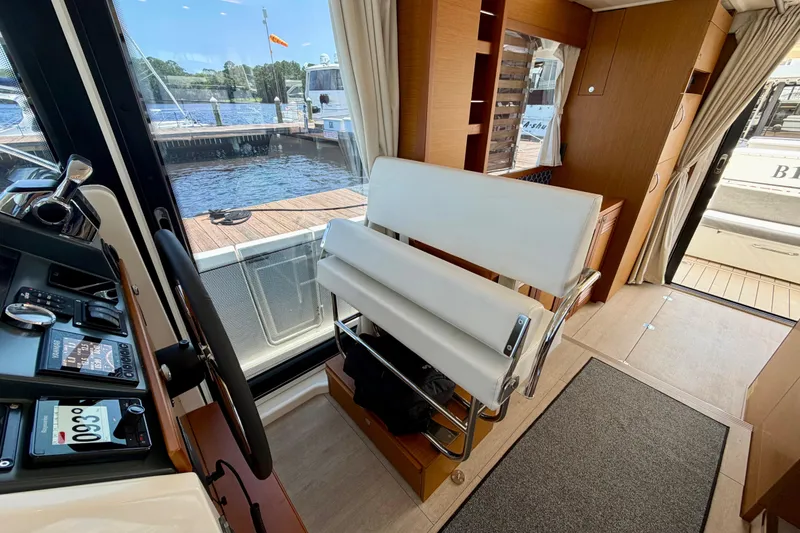Slide: The Image of Interior view of 2025 Beneteau Swift Trawler 41 Fly, featuring helm and seating area. - 24
