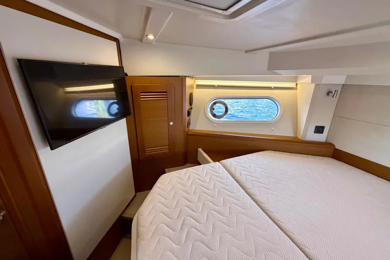 Slide: The Image of Luxurious cabin interior of 2025 Beneteau Swift Trawler 41 Fly with TV and porthole view. - 26