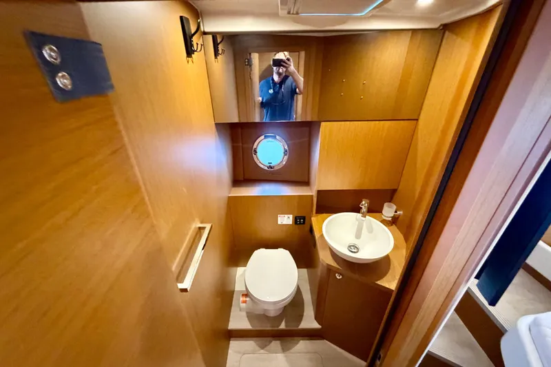 Slide: The Image of Bathroom interior of 2025 Beneteau Swift Trawler 41 Fly, featuring modern fixtures and wood paneling. - 28